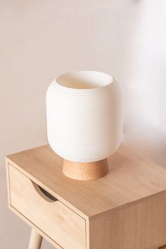 a white bowl sitting on top of a wooden table next to a drawer with drawers