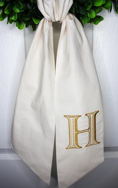 the monogrammed initial h is hanging on a door hanger with greenery behind it