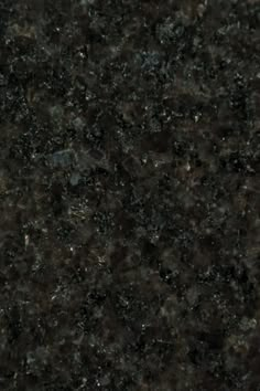 a close up view of a black granite counter top with dark brown speckles