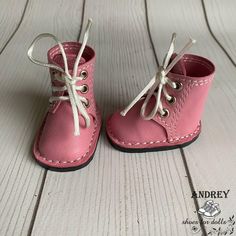 a pair of pink baby shoes with white laces