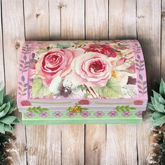 a pink and green box with flowers painted on it