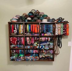 a wooden shelf filled with lots of bracelets and other items on top of it