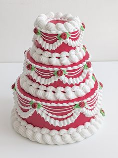 a three tiered cake with red and white icing on it's sides