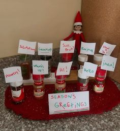 a table topped with lots of jars filled with different types of condiments and signs