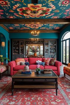 a living room with red couches and colorful ceiling murals on the walls above them