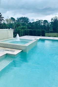 an outdoor swimming pool with steps leading up to it and a fountain in the middle