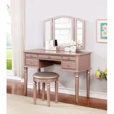 a pink vanity table with mirror and stool