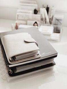 a stack of notebooks sitting on top of a white table next to each other