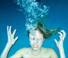 a woman under water with her hair in the air