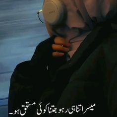 a person with headphones in their hands and an arabic text on the bottom right corner