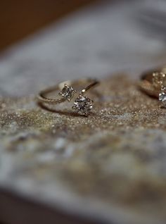 two diamond rings sitting on top of a table