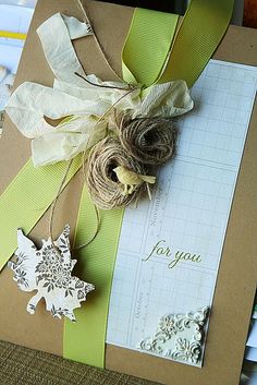 a box with some paper decorations on top of it and a tag attached to it