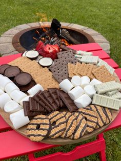 a fire pit with marshmallows, chocolate and graham crackers on it