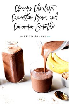 two glasses filled with chocolate and cinnamon smoothie next to bananas on a white surface