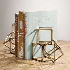 two books are sitting next to each other on a table with a bookend in the shape of a chair