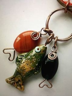 a keychain with a fish charm attached to it's side and a bead in the middle