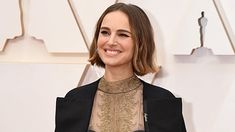 an image of a woman smiling on the oscars red carpet with her hair pulled back