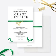 the grand opening card is next to scissors and green ribbon on top of white paper