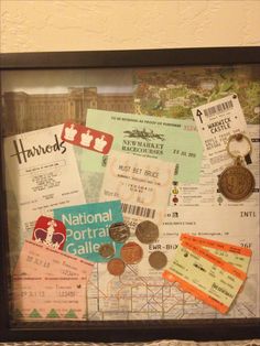 a display case with tickets and other items in the frame on top of a table