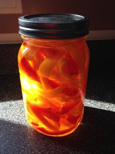 a jar filled with jelly beans sitting on top of a counter next to a window