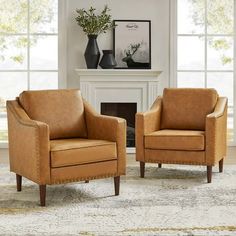 two tan chairs sitting in front of a fireplace with vases on the mantel