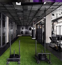 an indoor gym with artificial turf and exercise equipment