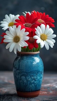 a blue vase filled with white and red flowers