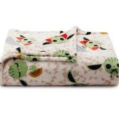 a white blanket with green cats on it