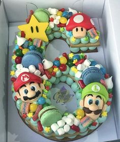 a birthday cake in the shape of a number with mario and luigi's faces on it