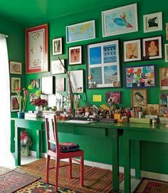 a green desk with many pictures on the wall