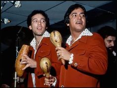 two men in red jackets holding bread and talking