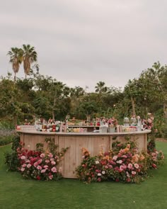 an outdoor bar surrounded by flowers and greenery