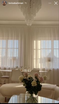 a vase filled with flowers sitting on top of a table next to a white couch