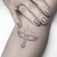 a woman's arm with a small bird tattoo on the left side of her leg