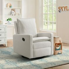 a white recliner chair sitting on top of a rug in front of a window