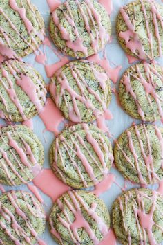 cookies with pink icing and sprinkles are on a baking sheet, ready to be eaten