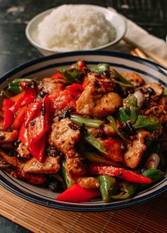 a plate full of chicken and peppers with rice