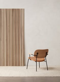 a chair sitting in front of a wall with vertical slatted panels on it