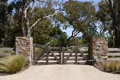 a stone and wood gate leads into a grassy area