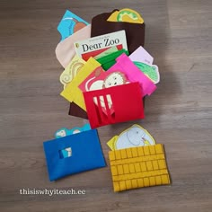 there are many different colored paper bags on the floor and one has a book in it