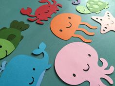 some cut out animals on a table with water droplets and sea creatures in the background