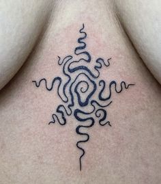 a tattoo on the back of a woman's chest with swirls and circles