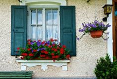 flowers are growing in the window boxes and on the windowsill