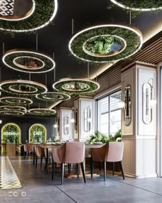 the interior of a restaurant with circular lights hanging from the ceiling and chairs around tables