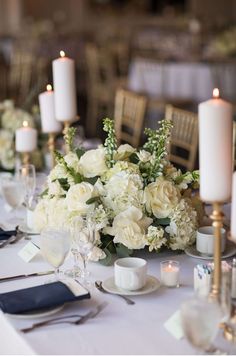 the table is set with white flowers and candles