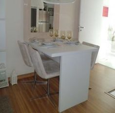 a dining room table and chairs with wine glasses on the counter top in front of it