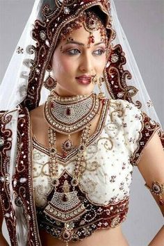 a woman wearing a bridal outfit and jewelry