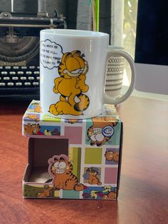 a winnie the pooh coffee mug sitting on top of a box