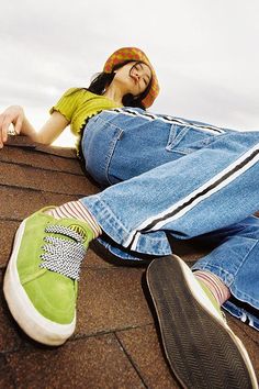 a woman laying on top of a roof with her feet up against the shingles