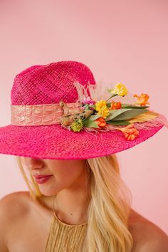 Be the life of the party with this playful CROWD FAVORITE SUN HAT! Featuring a pink leather band, gold horse ornament, and vibrant pink and white feathers, this hat is perfect for a day at the Derby or any summer soiree. Don't forget the fun yellow, orange, and pink flowers for a pop of color. This hat is ONE OF A KIND, created by our owner Stephanie. To receive item quicker, expedited shipping is available at checkout. Pink Mini Hat For Festivals, Pink Summer Festival Hats, Chic Pink Hat For Vacation, Chic Pink Vacation Hat, Pink Summer Hat For Garden Party, Pink Fedora Straw Hat For Summer, Pink Summer Party Hat, Whimsical Pink Summer Hat, Chic Pink Straw Hat For Vacation